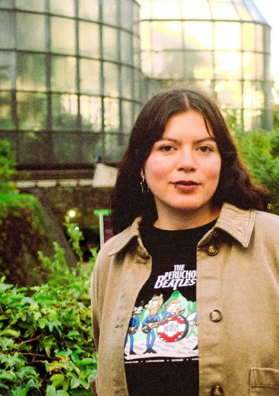 Retrato de una joven frente a un invernadero